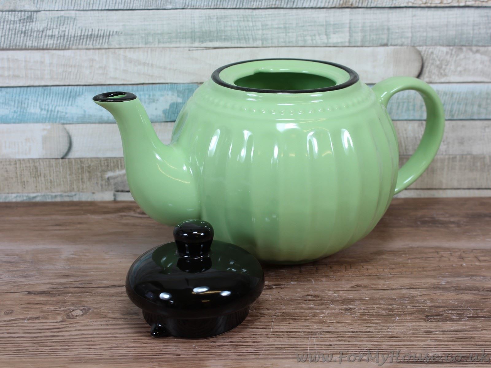 Green ceramic teapot with black lid and ribbed design afternoon tea